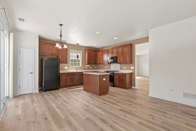 14300 Sundance Dr, Huntley, IL 60142 - kitchen featuring black appliances, light wood-type flooring, light countertops, a center island, and recessed lighting