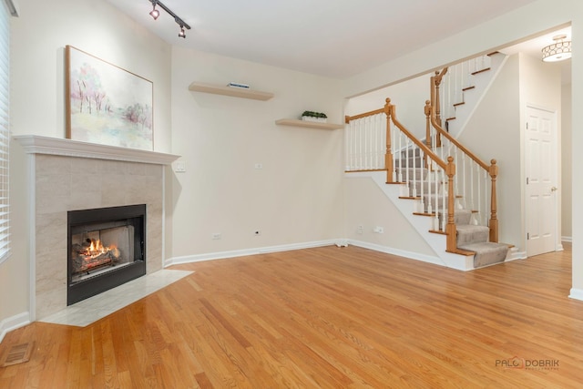 1804 Monroe Ct, Glenview, IL 60025 - unfurnished living room with wood finished floors, stairs, a tile fireplace, and rail lighting