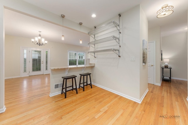 1804 Monroe Ct, Glenview, IL 60025 - kitchen with a kitchen breakfast bar, light wood finished floors, a chandelier, pendant lighting, and a peninsula