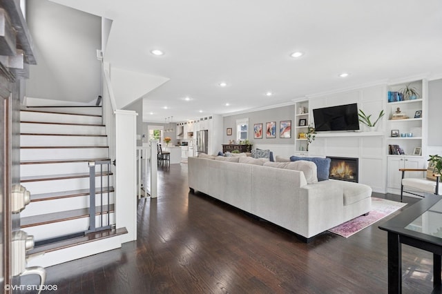 5106 W Eddy St, Chicago, IL 60641 - living room featuring a glass covered fireplace, recessed lighting, dark wood finished floors, stairway, and crown molding
