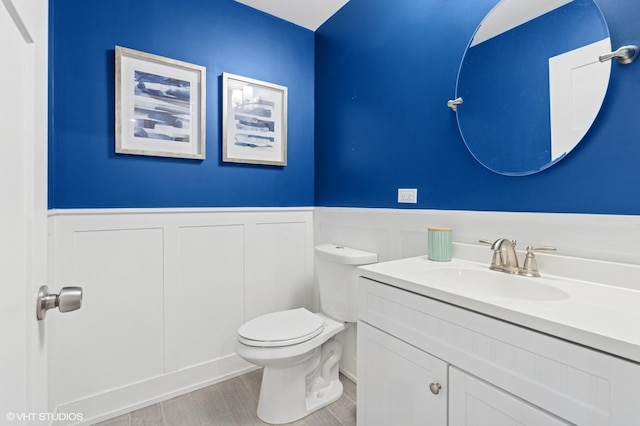 5106 W Eddy St, Chicago, IL 60641 - half bath with vanity, wainscoting, wood finished floors, and a decorative wall