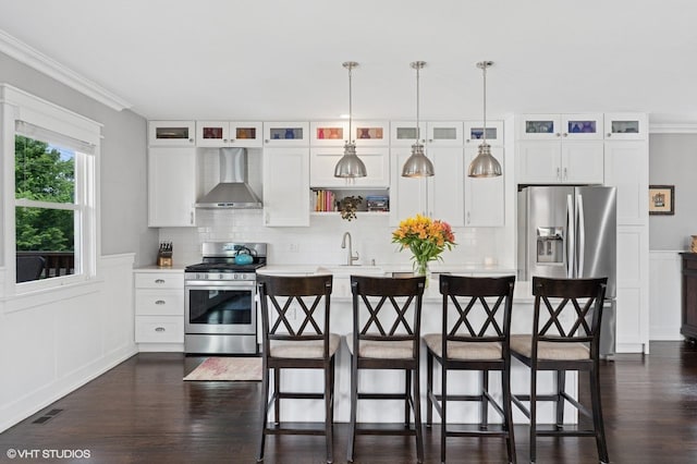 5106 W Eddy St, Chicago, IL 60641 - kitchen with gas range, wall chimney exhaust hood, crown molding, light countertops, and dark wood-style flooring