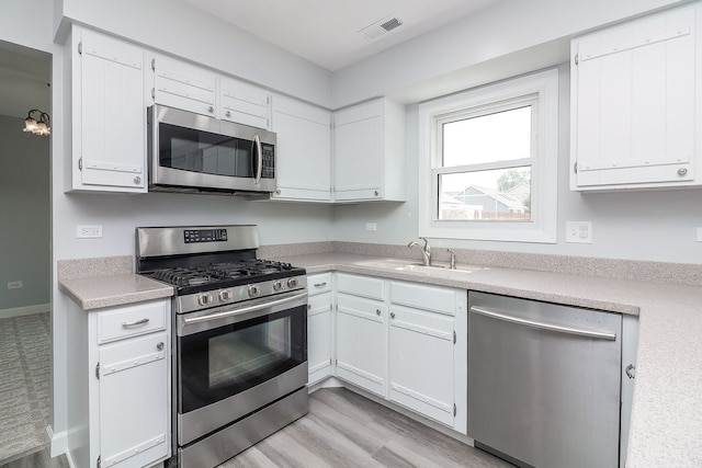 1557 Scottdale Cir, Wheaton, IL 60189 - kitchen featuring stainless steel appliances, light countertops, white cabinets, and light wood-style floors