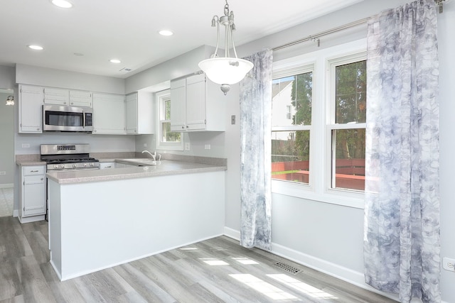 1557 Scottdale Cir, Wheaton, IL 60189 - kitchen featuring appliances with stainless steel finishes, light wood-style flooring, light countertops, white cabinetry, and recessed lighting
