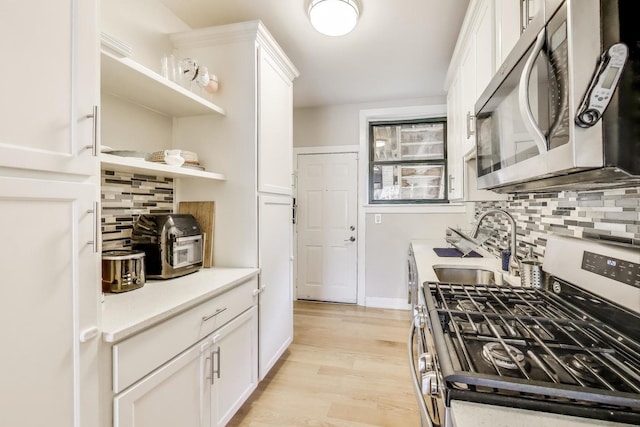 7021 N Sheridan Rd Unit 1, Chicago, IL 60626 - kitchen with stainless steel appliances, white cabinets, light countertops, and backsplash