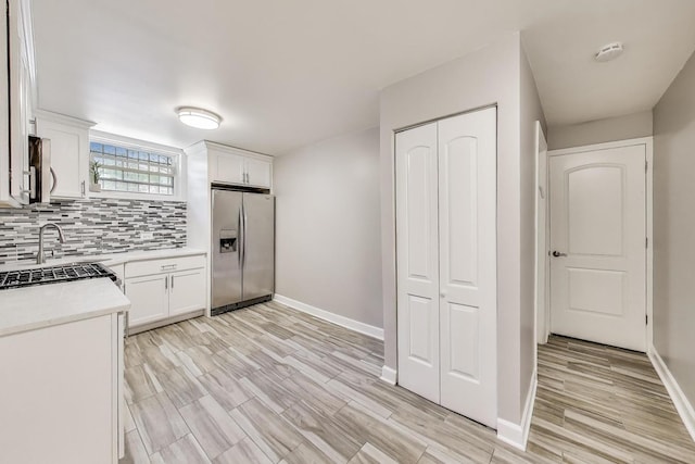 7021 N Sheridan Rd Unit 1, Chicago, IL 60626 - kitchen with stainless steel fridge, light countertops, backsplash, and white cabinets