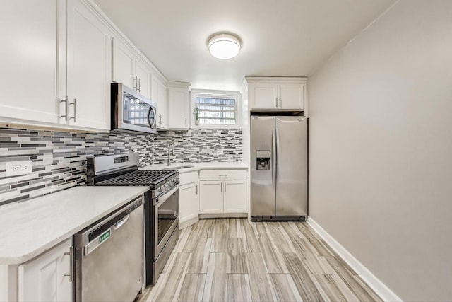 7021 N Sheridan Rd Unit 1, Chicago, IL 60626 - kitchen featuring stainless steel appliances, decorative backsplash, light countertops, white cabinets, and light wood finished floors