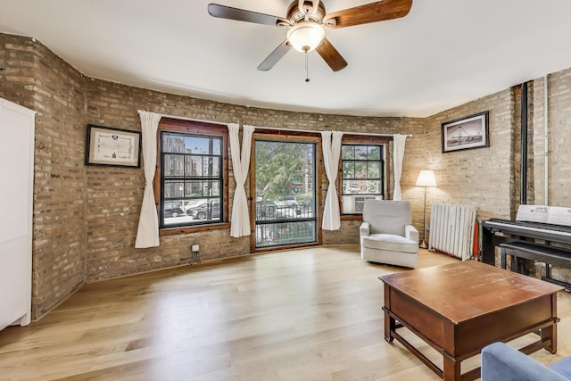 7021 N Sheridan Rd Unit 1, Chicago, IL 60626 - sitting room featuring radiator, brick wall, wood finished floors, and ceiling fan