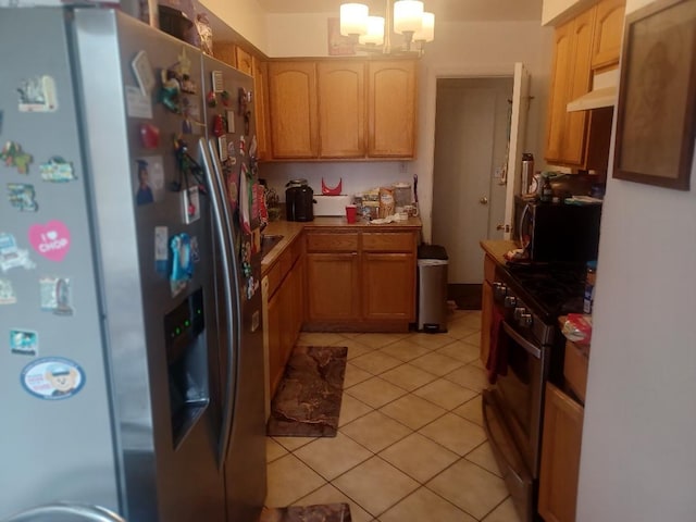 8506 S Jeffery Blvd, Chicago, IL 60617 - kitchen with stainless steel appliances, under cabinet range hood, a chandelier, light tile patterned floors, and light countertops
