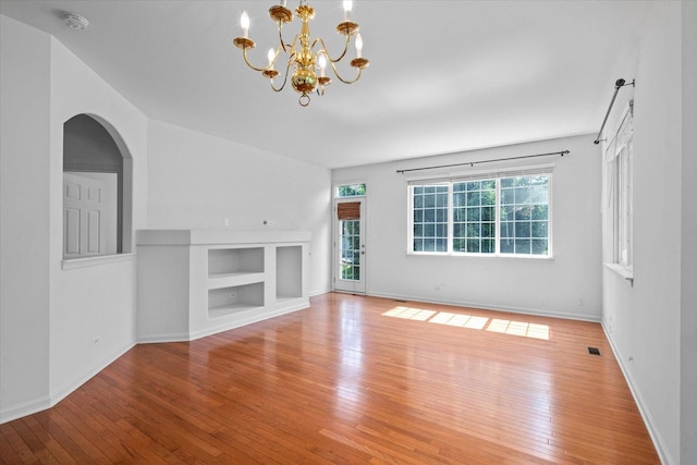 270 Birch Ln, Saint Charles, IL 60175 - unfurnished living room featuring light wood finished floors, a chandelier, and arched walkways