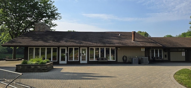 32 Montego Colony Unit 7, Fox Lake, IL 60020 - back of house featuring a chimney and a shingled roof