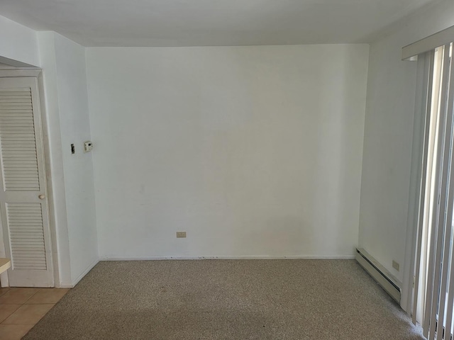 32 Montego Colony Unit 7, Fox Lake, IL 60020 - empty room with a baseboard heating unit, light tile patterned floors, and light carpet