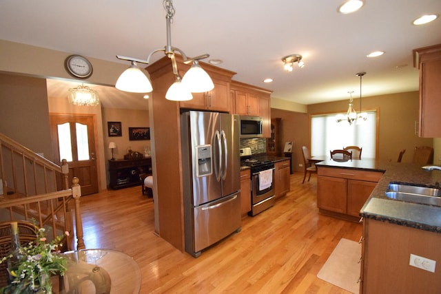 963 E Castlewood Ln, Bartlett, IL 60103 - kitchen featuring stainless steel appliances, dark countertops, light wood-style floors, a chandelier, and backsplash