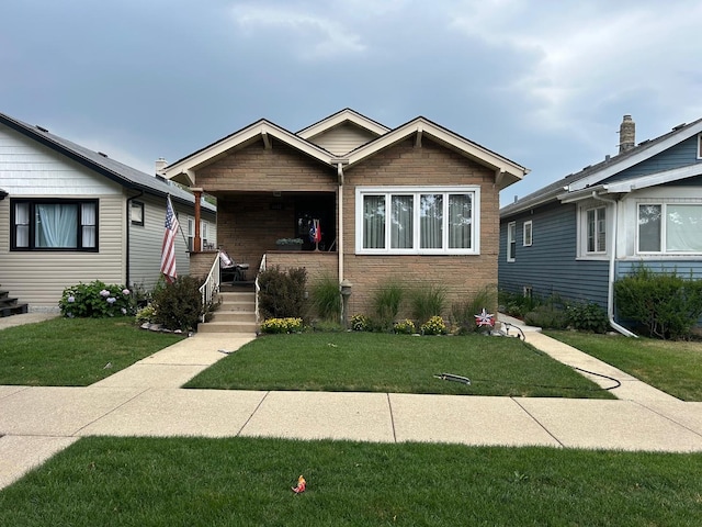5542 W Grace St, Chicago, IL 60641 - view of front facade with covered porch, a front lawn, and stone siding