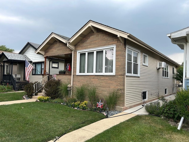 5542 W Grace St, Chicago, IL 60641 - view of front of home with stone siding, a front yard, an AC wall unit, and covered porch