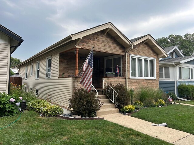5542 W Grace St, Chicago, IL 60641 - view of front of property featuring a front yard, stone siding, and cooling unit