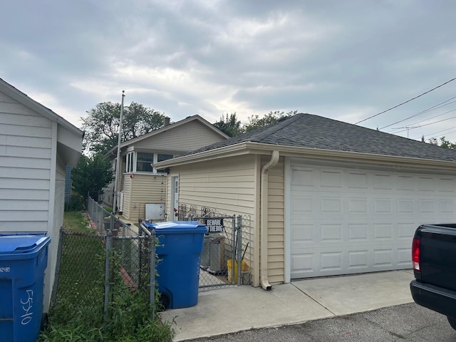 5542 W Grace St, Chicago, IL 60641 - view of home's exterior featuring a shingled roof, a garage, and an outbuilding