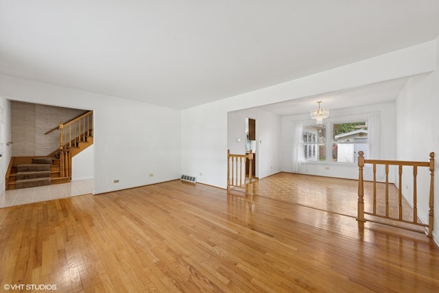 9061 Primrose Ln, Hickory Hills, IL 60457 - unfurnished living room featuring a chandelier, light wood finished floors, and stairs