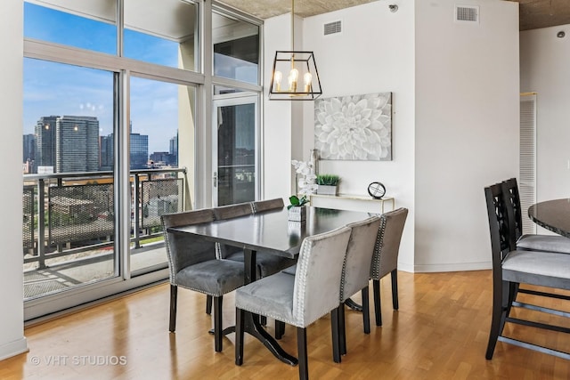 700 N Larrabee St Unit 1409, Chicago, IL 60654 - dining area with a chandelier, light wood-style flooring, plenty of natural light, a skyline view, and floor to ceiling windows