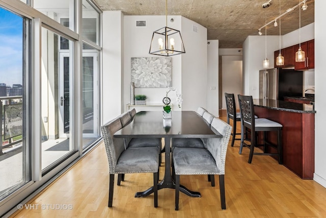 700 N Larrabee St Unit 1409, Chicago, IL 60654 - dining room featuring plenty of natural light, light wood-type flooring, a chandelier, rail lighting, and a wall of windows