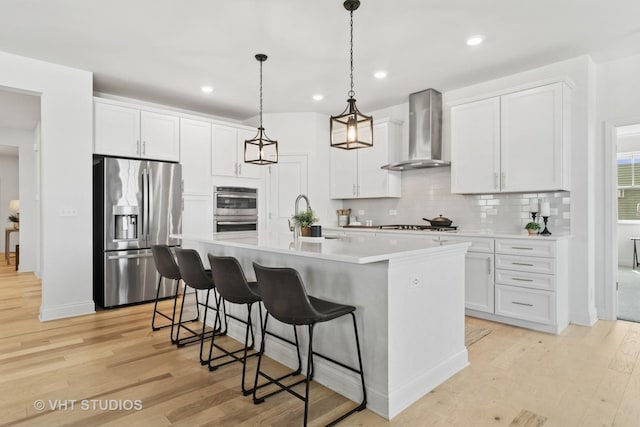 1140 River Birch Blvd, Crystal Lake, IL 60012 - kitchen featuring appliances with stainless steel finishes, wall chimney exhaust hood, light wood-type flooring, tasteful backsplash, and white cabinets