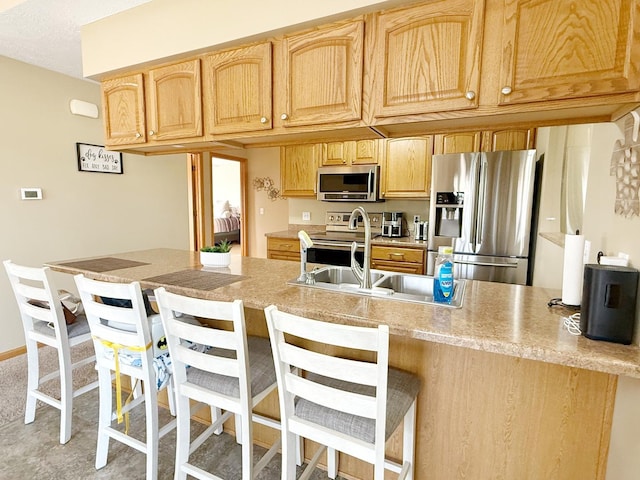 15538 Finley Way Unit 2, South Beloit, IL 61080 - kitchen with stainless steel appliances, a peninsula, light brown cabinetry, light countertops, and a kitchen bar