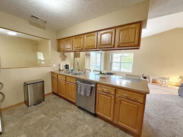 15538 Finley Way Unit 2, South Beloit, IL 61080 - kitchen with stainless steel dishwasher, a peninsula, brown cabinets, a textured ceiling, and light carpet