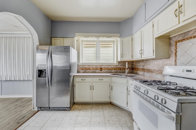 3928 W 63rd Pl, Chicago, IL 60629 - kitchen featuring stainless steel fridge, white gas stove, decorative backsplash, light countertops, and light tile patterned floors