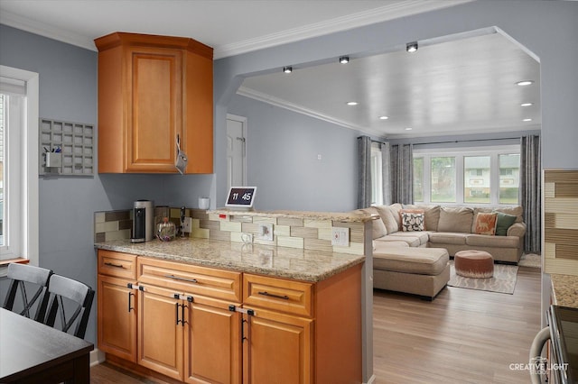 409 N Addison Rd, Villa Park, IL 60181 - kitchen featuring light wood-type flooring, light stone counters, crown molding, open floor plan, and a peninsula