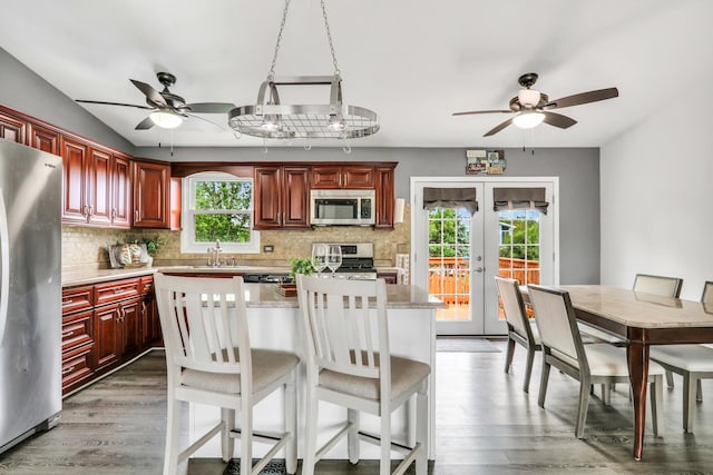 513 White Birch Rd, Lindenhurst, IL 60046 - kitchen featuring appliances with stainless steel finishes, a ceiling fan, reddish brown cabinets, and backsplash