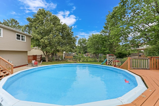 513 White Birch Rd, Lindenhurst, IL 60046 - swimming pool featuring a wooden deck, a fenced backyard, and a playground