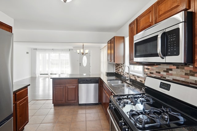 5222 Wright Ter, Skokie, IL 60077 - kitchen featuring appliances with stainless steel finishes, a chandelier, a peninsula, decorative backsplash, and light tile patterned floors