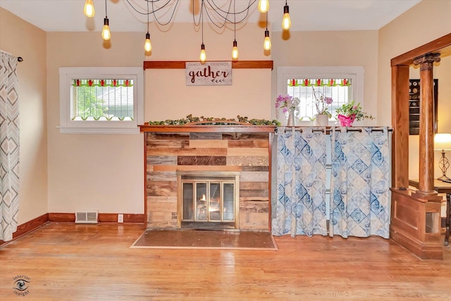 9826 S Walden Pkwy, Chicago, IL 60643 - unfurnished living room with wood finished floors, healthy amount of natural light, a stone fireplace, and ornate columns