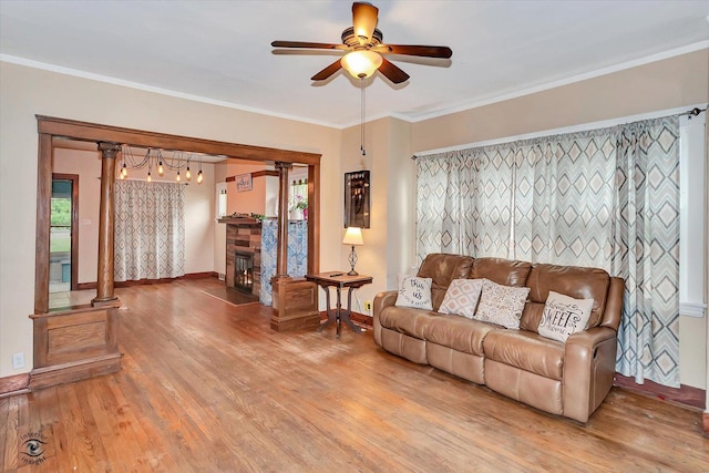 9826 S Walden Pkwy, Chicago, IL 60643 - living room featuring ceiling fan, light wood-type flooring, ornamental molding, a stone fireplace, and decorative columns