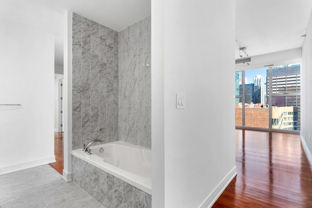 550 N Saint Clair St Unit 2301, Chicago, IL 60611 - bathroom featuring tiled bath, wood finished floors, and a view of city