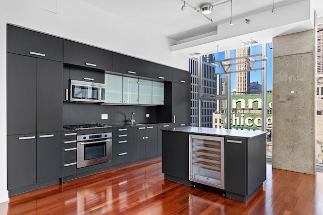 550 N Saint Clair St Unit 2301, Chicago, IL 60611 - kitchen featuring appliances with stainless steel finishes, wine cooler, dark wood-style floors, dark cabinetry, and modern cabinets