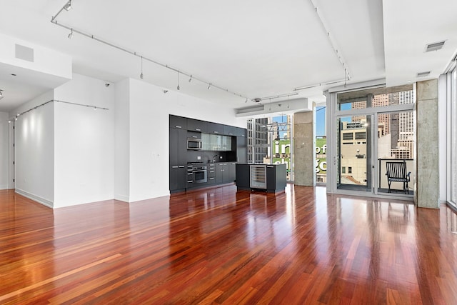 550 N Saint Clair St Unit 2301, Chicago, IL 60611 - unfurnished living room featuring dark wood-style floors, track lighting, and a wall of windows