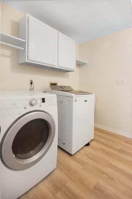 3302 Rustic Ln, Crown Point, IN 46307 - washroom featuring separate washer and dryer, cabinet space, and light wood-style floors