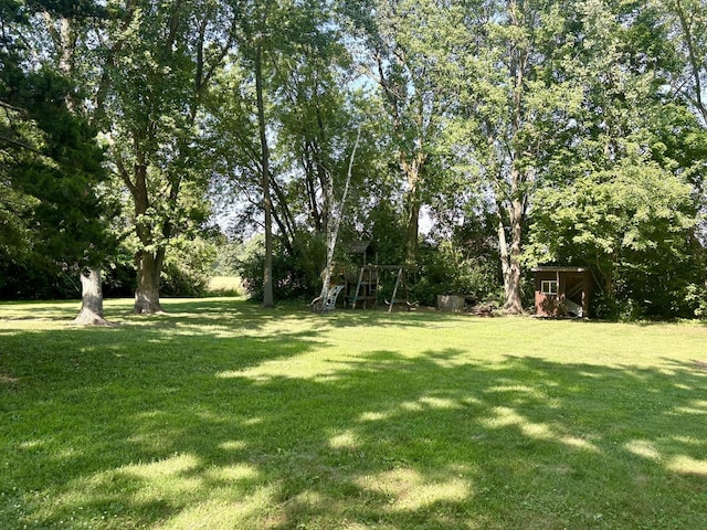 214 Tiverton Rd, Kankakee, IL 60901 - view of grassy yard with a playground, a storage shed, and view of scattered trees