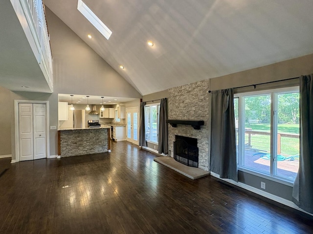 214 Tiverton Rd, Kankakee, IL 60901 - unfurnished living room with high vaulted ceiling, a skylight, dark wood-style flooring, and a fireplace