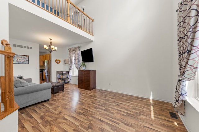 7425 Rosewind Dr, Plainfield, IL 60586 - living room featuring wood finished floors, a chandelier, and a towering ceiling