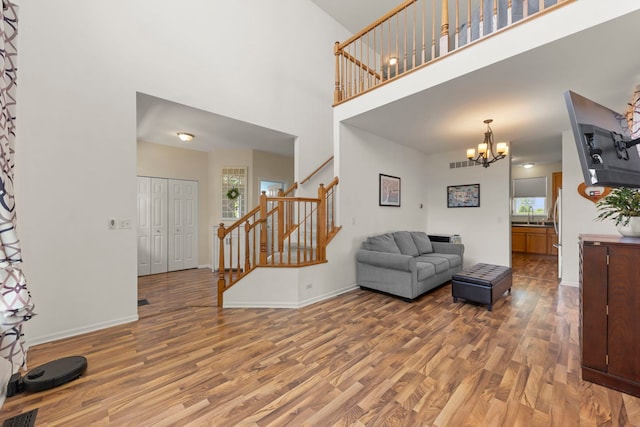 7425 Rosewind Dr, Plainfield, IL 60586 - living area with wood finished floors, stairway, plenty of natural light, a high ceiling, and a chandelier