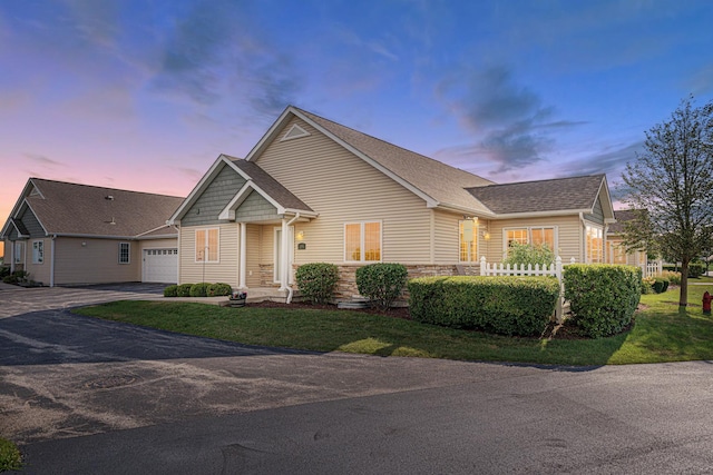 2182 Waterbury Ln E Unit 2182, Sycamore, IL 60178 - view of front of property with asphalt driveway, an attached garage, a front yard, and stone siding