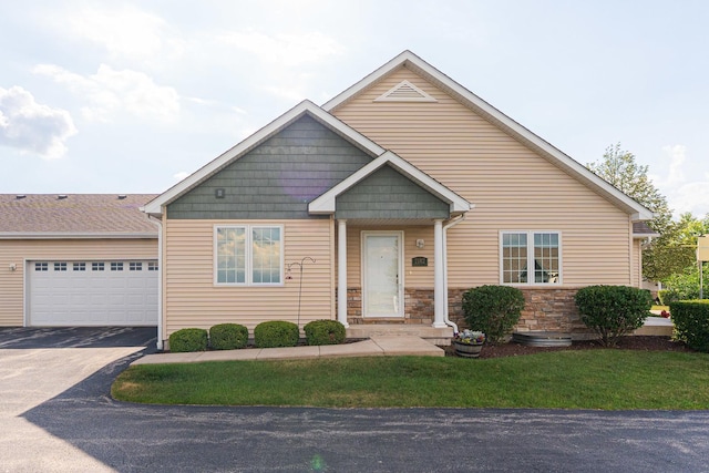 2182 Waterbury Ln E Unit 2182, Sycamore, IL 60178 - view of front of house featuring driveway, a front lawn, stone siding, and a garage