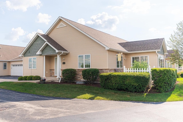 2182 Waterbury Ln E Unit 2182, Sycamore, IL 60178 - view of front facade featuring roof with shingles, a front lawn, a garage, stone siding, and asphalt driveway