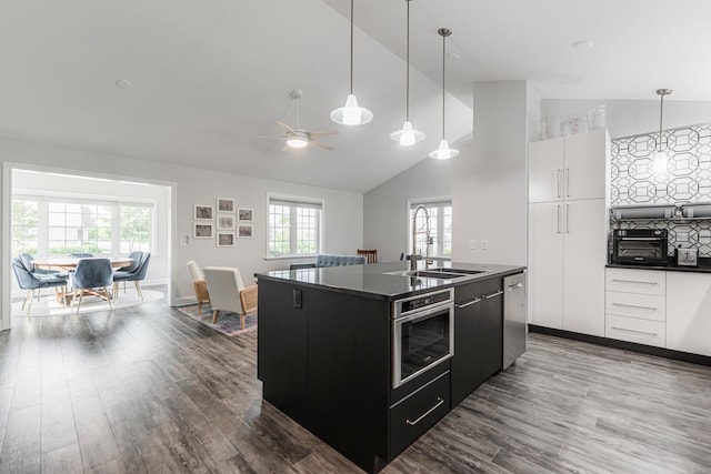 2182 Waterbury Ln E Unit 2182, Sycamore, IL 60178 - kitchen with dark countertops, dark cabinets, a center island with sink, dark wood finished floors, and ceiling fan