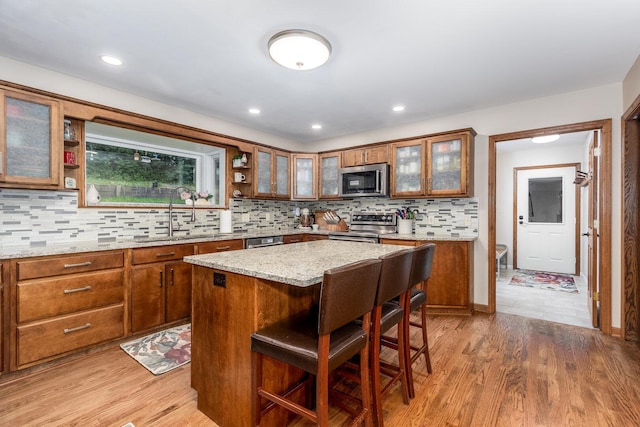 2519 Cherie Ln, Ottawa, IL 61350 - kitchen featuring stainless steel appliances, brown cabinetry, a breakfast bar area, light wood-type flooring, and recessed lighting