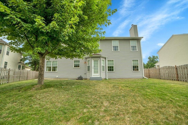 157 Concord Dr, Oswego, IL 60543 - rear view of house with entry steps, a chimney, and a fenced backyard