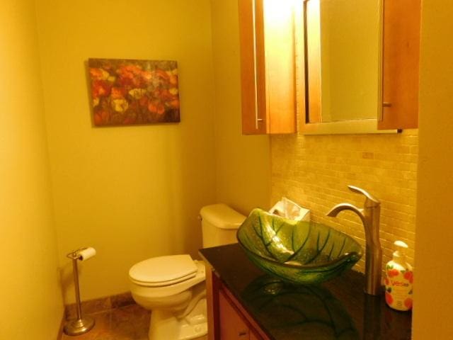 711 Glendale Ave, Rockford, IL 61108 - half bathroom with backsplash, vanity, and tile patterned flooring