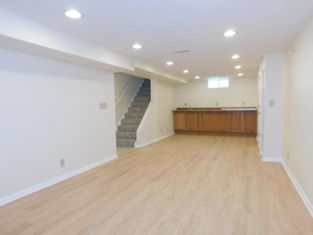 711 Glendale Ave, Rockford, IL 61108 - basement featuring light wood-style flooring, recessed lighting, stairway, and bar with sink